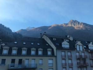 ein Gebäude mit einem Berg im Hintergrund in der Unterkunft Cosy T2 mezzanine pour 4 personnes in Cauterets