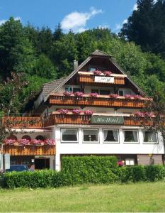 a large white building with flowers on the balconies at Decker's Bio Hotel zum Lamm in Baiersbronn
