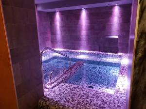a swimming pool with purple lights in a bathroom at Hotel Canin in Sella Nevea