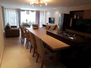 cocina y comedor con mesa larga y sillas en Apartamento Excelente Tambaú, en João Pessoa