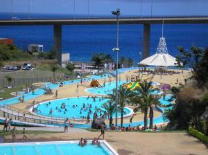 uma grande piscina com pessoas ao lado do oceano em Plaza Charming Flat em Santa Cruz