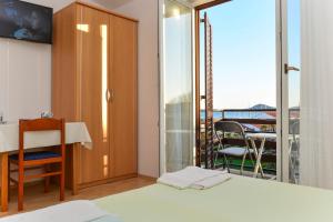 a bedroom with a bed and a balcony with a table at Apartments and Rooms SummerCity Life in Vodice
