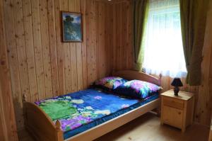 a small bedroom with a bed with a window at Domki Jaśmin 781-012-181 in Polańczyk