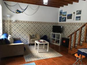 a living room with a couch and a tv at Casa do Mar in Ribeira Seca do Porto