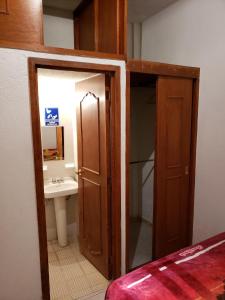 a bathroom with a sink and an open door at Hotel Anturio in Huajuapan de León