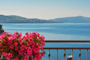 a balcony with pink flowers and a view of the water at Apartments Mira in Trogir