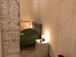 - une chambre avec un lit vert et une table éclairée dans l'établissement CASA CAIROLI PUTIGNANO, à Putignano