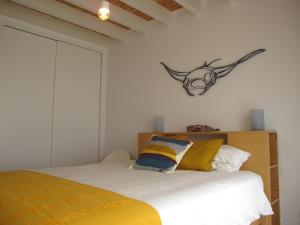 a bedroom with a bed with yellow and blue pillows at Canto do Nemo in Canto da Areia