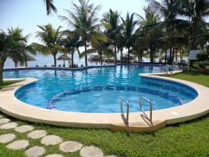 una piscina en un complejo con palmeras en Casita del Mar en Cancún