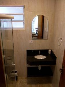 a bathroom with a sink and a mirror at Chalés Pousada Serra Negra in Serra Negra