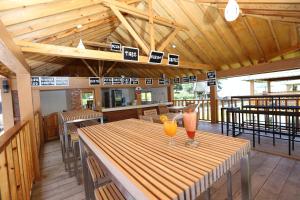 un ristorante con un tavolo in legno con due bicchieri sopra di Toba Village Inn a Tuk Tuk
