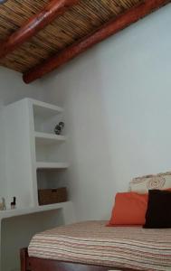 1 dormitorio con cama y pared blanca en La Cabañita de Tilcara en Tilcara