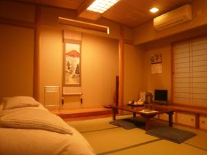 a room with a bed and a desk and a television at Kakiya Ryokan in Kamakura +23 photos