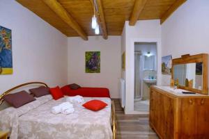 ラメーツィア・テルメにあるB&B Parva Domusのベッドルーム1室(赤い枕とシンク付きのベッド1台付)