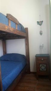 a bedroom with a bunk bed and a night stand at Cabañas Las Acacias in San Clemente del Tuyú