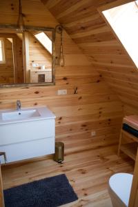 Baño en una cabaña de madera con lavabo y espejo en Wrzosowe Zacisze, en Siepraw