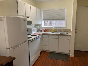 a kitchen with a white refrigerator and a sink at Townhouse Inn & Suites in Klamath Falls