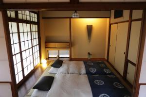 a bedroom with two beds in a room with windows at 一日一組 湘南の古民家貸別荘 Traditional Beach Villa in Chigasaki