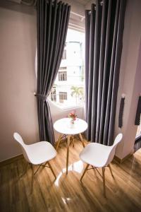 uma mesa e duas cadeiras num quarto com uma janela em SUNNY HOTEL em Quy Nhon
