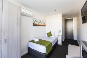 a hotel room with a bed and a television at Icon on Isa in Mount Isa +10 photos