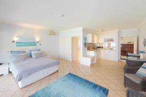 1 dormitorio con 1 cama y sala de estar en Paradise Beach Apartments en Sanctuary Point