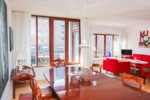 ein Wohnzimmer mit einem roten Sofa und einem Tisch in der Unterkunft Bright, spacious and trendy apartment in CPH in Kopenhagen