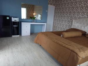 a bedroom with a large bed and a refrigerator at Pondok Oma II in Lasikin