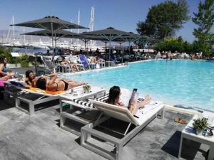 a group of people laying on lounge chairs by a pool at Seaview apartment in Piraeus