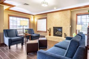 a living room with blue furniture and a fireplace at Comfort Inn & Suites Gillette near Campbell Medical Center in Gillette