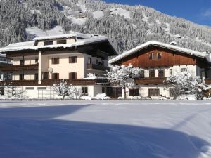 ein großes Gebäude mit einem schneebedeckten Feld davor in der Unterkunft Appartement Schneeberger in Zell am Ziller