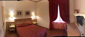 a bedroom with a bed and a window and a television at Hotel Quadrifoglio by Mancini in Rome