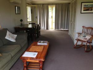 a living room with a couch and a coffee table at Toscana on Greenhills in Sutton Forest