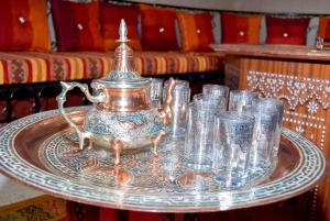 a tray with a tea pot and glasses on a table at Dar nadia bendriss in Ouarzazate