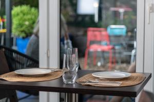 - une table avec deux assiettes et des verres dans l'établissement Hotel Birsighof Basel City Center, à Bâle