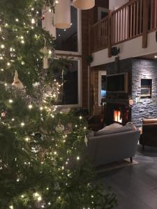 a christmas tree in a living room with a fireplace at The Little Elk in Ruka