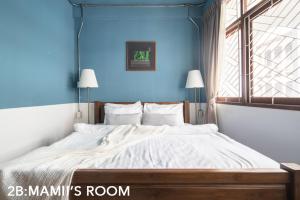 una camera con un grande letto con una parete blu di Better Moon Guesthouse a Bangkok