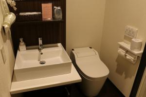 高松市にあるホテル望海荘のバスルーム(白い洗面台、トイレ付)
