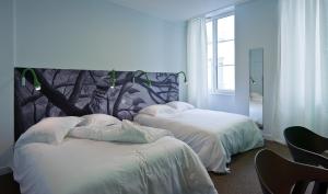 1 Schlafzimmer mit 2 Betten und einem großen Fenster in der Unterkunft HOTEL CONTINENTAL in Saint-Étienne