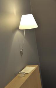 eine Lampe auf einem Tisch mit einem Papier darauf in der Unterkunft HOTEL CONTINENTAL in Saint-Étienne
