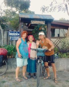 um grupo de três mulheres ao lado de uma bicicleta em Rim Than View Resort em Ubon Ratchathani