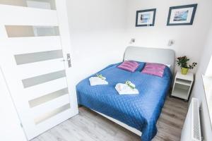 ein kleines Schlafzimmer mit einem Bett und zwei Handtüchern in der Unterkunft Apartamenty Izerskie - ul. Cicha 13D-E in Świeradów-Zdrój