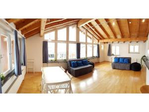 een grote woonkamer met een tafel en blauwe kussens bij Ferienhaus Lungern see-you in Lungern