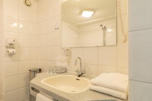 
a bathroom with a sink, toilet and bathtub at Fletcher Resort-Hotel Amelander Kaap in Hollum
