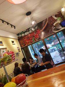 a group of people sitting at a counter in a restaurant at Amaretto & Caffe Hostel in Surat Thani