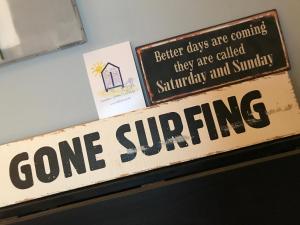 Ein Schild, auf dem steht: Surfen im Regal in der Unterkunft Villa Trémail - La plage au pied de votre chambre in Wimereux