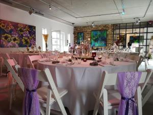 a table with pink table cloths and chairs in a room at Kunst Pension Frahm in Basthorst