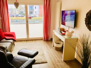 ein Wohnzimmer mit einem Sofa und einem TV in der Unterkunft Apartment Alleestraße in Büsum