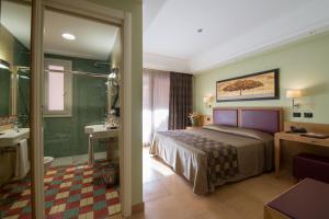 a hotel room with a bed and a bathroom at Artemis Hotel in Cefalù