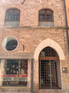 un edificio de ladrillo con 2 ventanas arqueadas en Affittacamere Arco Polinori, en Foligno