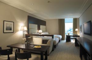 a hotel room with a bed and a table and chairs at BREEV GWANGJU by LOTTE HOTELS, formerly Ramada Plaza by Wyndham Gwangju in Gwangju